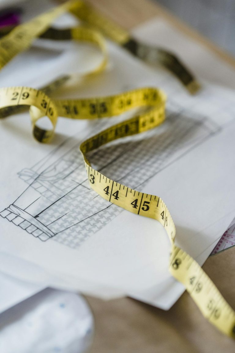 Measuring tape placed on sketches on table